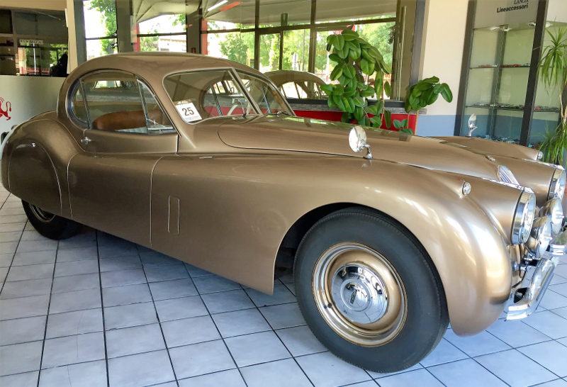 A brown classic car inside the car dealer.