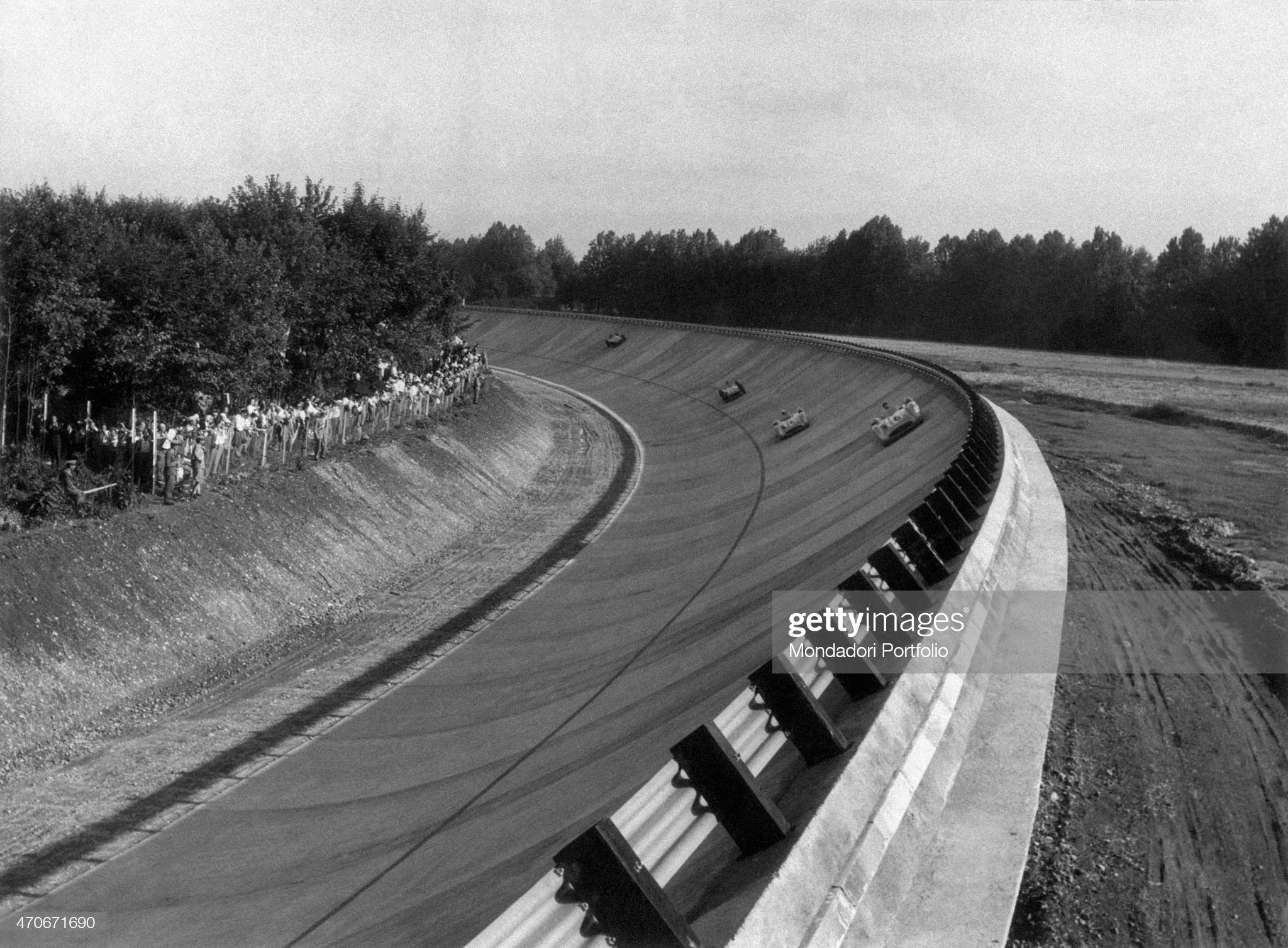 A banked curve at autodromo di Monza with 4 cars racing.