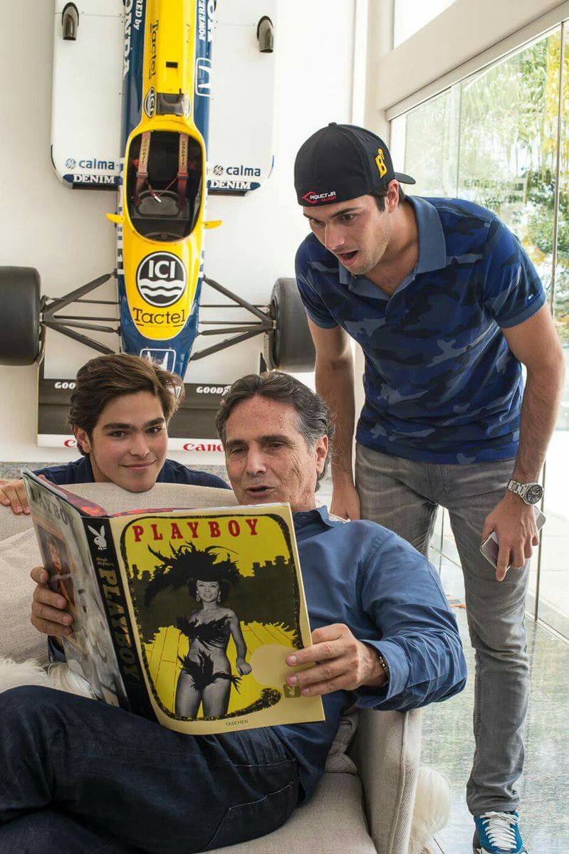 Nelson Piquet, sitting in front of his Williams FW11, reading a “book” to his sons.