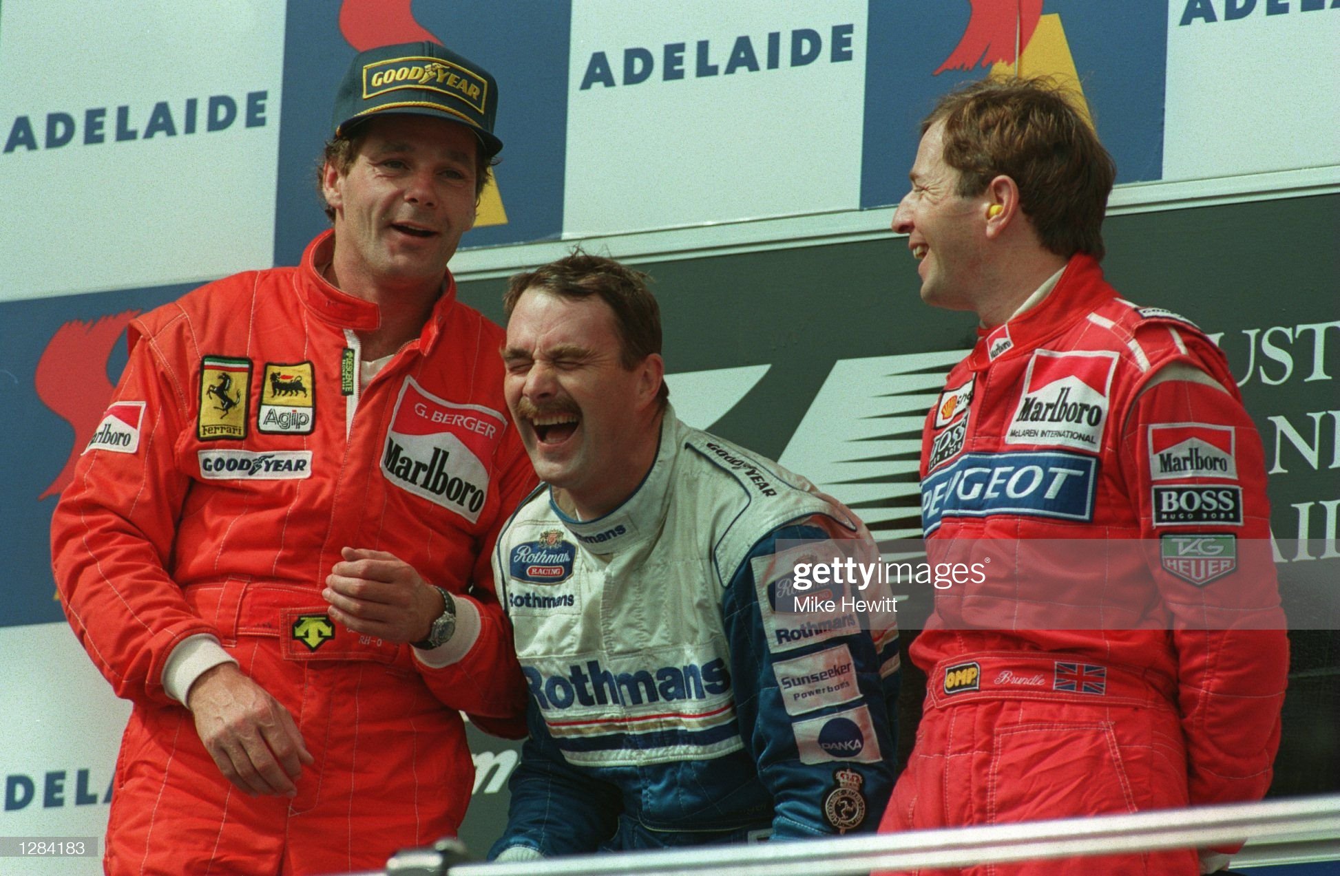 Left to right: second place finisher, Ferrari’s Gerhard Berger, winner, Nigel Mansell and Martin Brundle, the third place finisher, share a joke on the podium after the Australian Grand Prix in Adelaide on 13 November 1994. Credit: Mike Hewitt / Allsport.