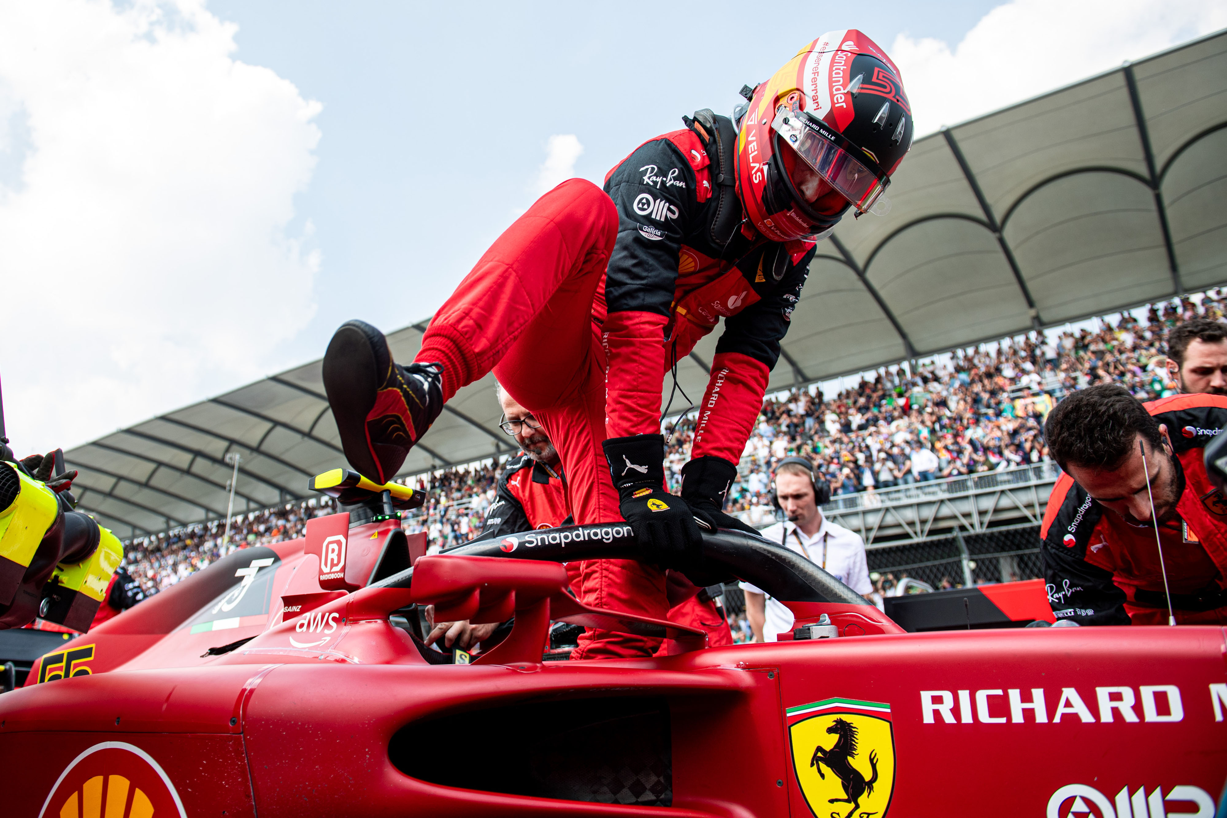 Carlos Sainz at the pits getting into his Ferrari. 