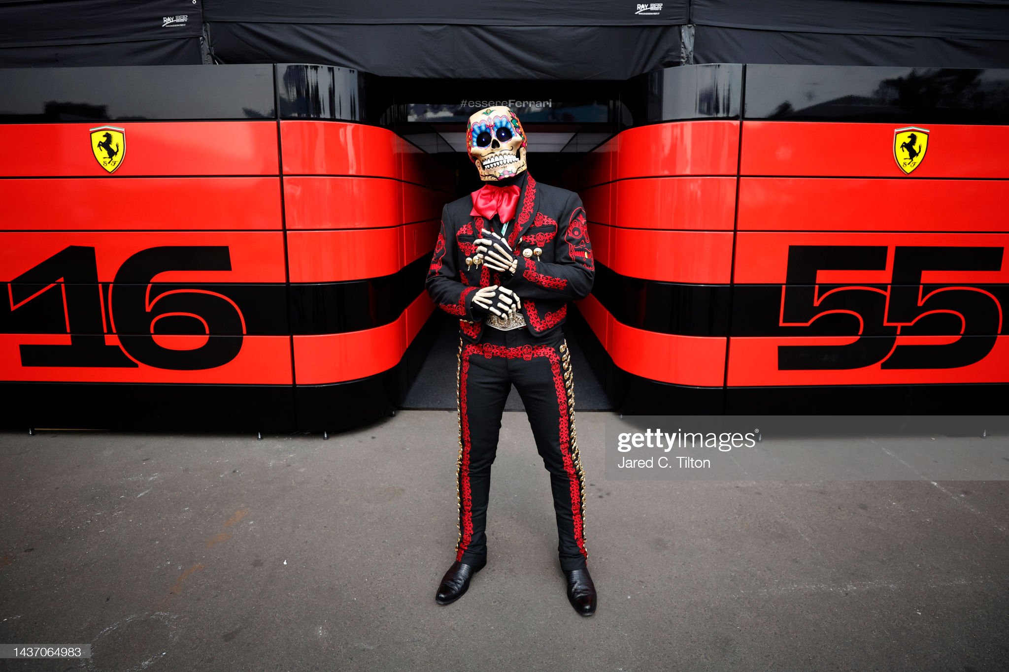 A Day of the Dead performer poses for a photo outside the Ferrari garage.