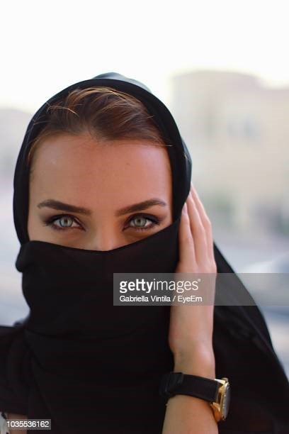 Portrait of woman covering face with headscarf. Photo taken in Doha, Qatar.