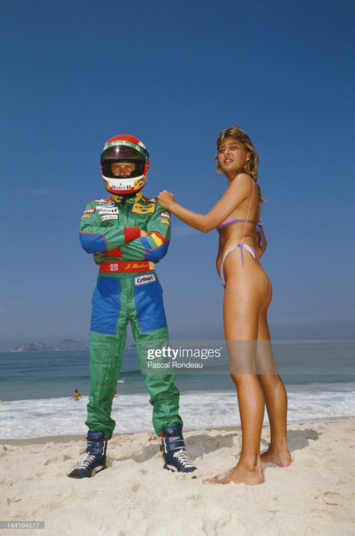 Johnny Herbert of Great Britain and driver of the n.20 Benetton B188 Ford V8 poses for a portrait, with a girl wearing a bikini, on the beach in Rio de Janeiro after practice for the Brazilian Grand Prix on 25th March 1989 at the Autodromo Internacional Nelson Piquet Jacarepagua circuit near Rio de Janeiro, Brazil. 