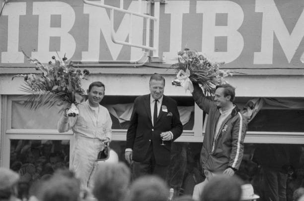 New Zealand racing drivers Bruce McLaren (left) and Chris Amon (right) with Ford CEO Henry Ford II (centre) on the podium after winning the 24 Hours of Le Mans, the 34th Grand Prix of Endurance in Le Mans, France, 19th June 1966. 