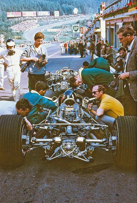 Jim Clark watching Graham Hill, on Lotus 49, consulting Colin Chapman.