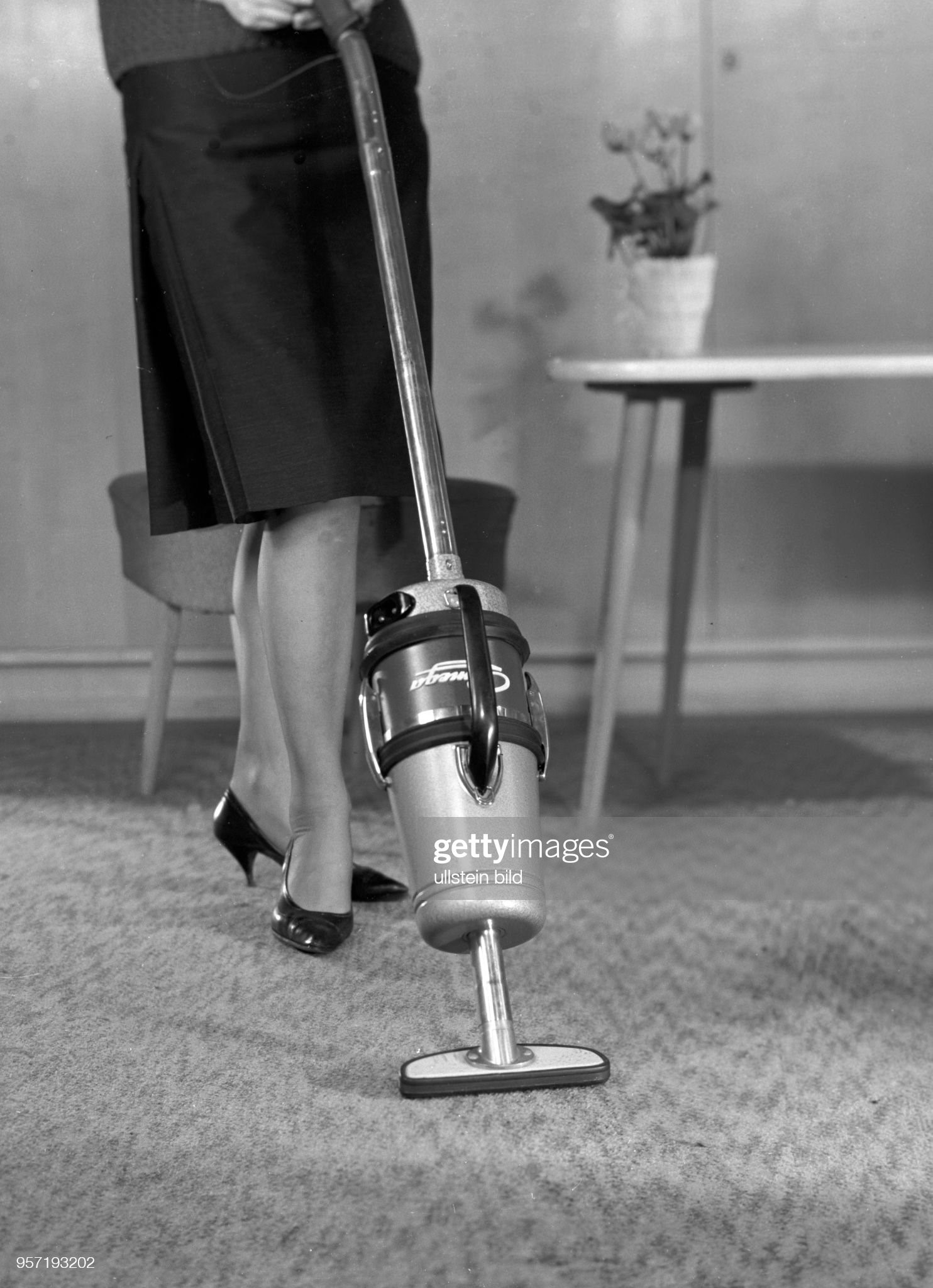 A woman from GDR pushes a vacuum cleaner across the carpet in November 1962. 
