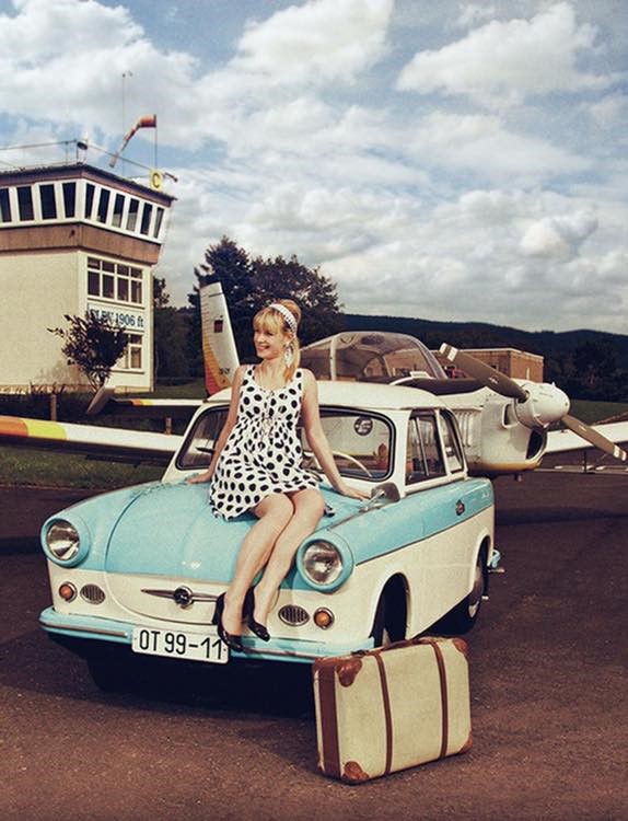 A girl on the front hood of a Trabant.