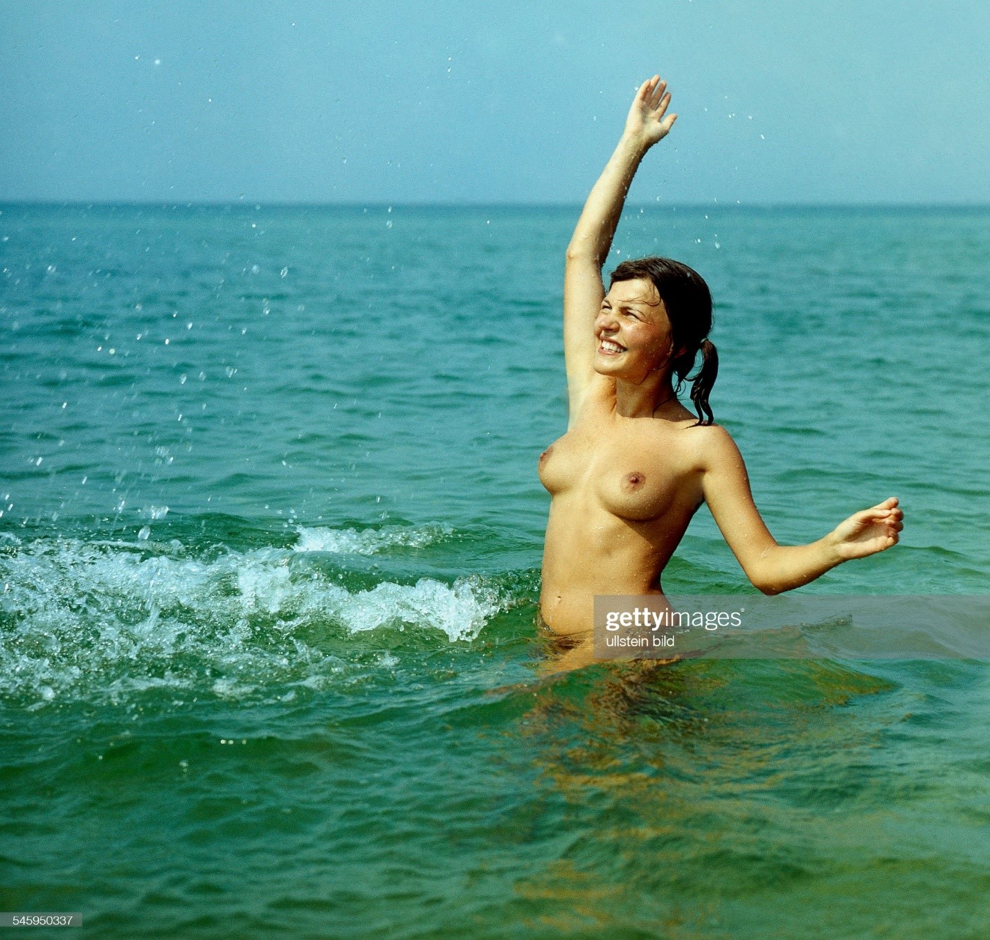 A young topless girl in the Baltic Sea at the nudist beach in 1977.
