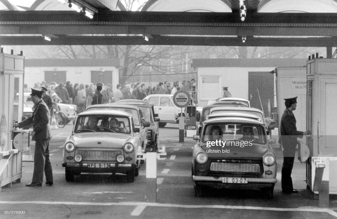 Long queues of pedestrians (in the background) and rows of drivers with Trabant cars who are waiting in a disciplined manner at the Bornholmerbrücke border crossing for clearance by the GDR border authorities, photographed on November 10th, 1989.