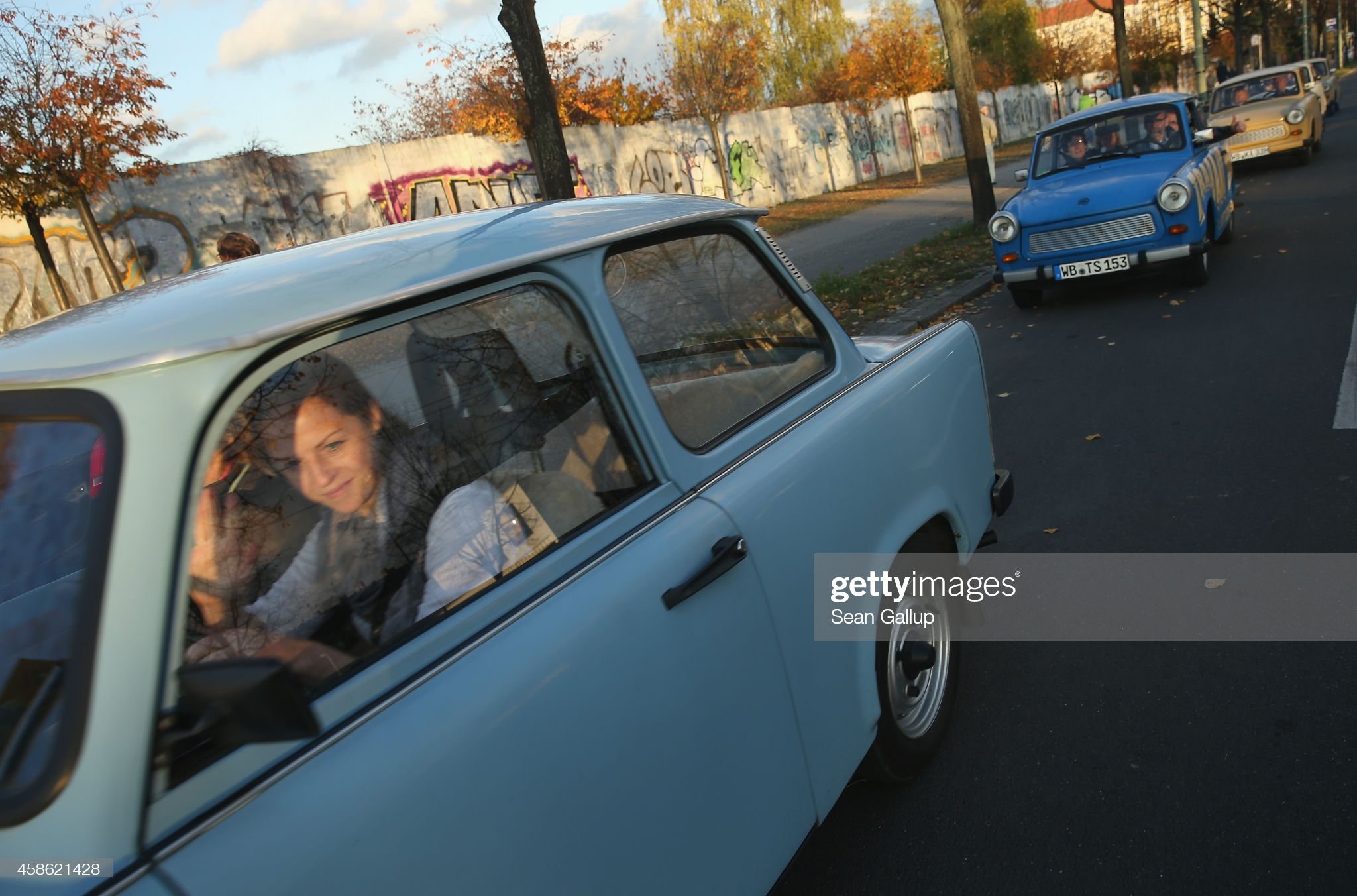 Visitors in East German-era Trabant cars drive next to a still-standing section of the Berlin Wall at Bornholmer Strasse, where nearly 25 years before East Germans crossed into West Berlin, the day before the 25th anniversary of the fall of the Wall on November 08, 2014 in Berlin, Germany. 