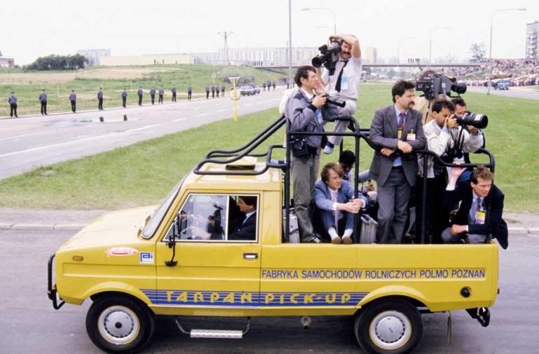 Reporters standing on board of a Tarpan during John Paul II's 1987 pilgrimage to Poland. 