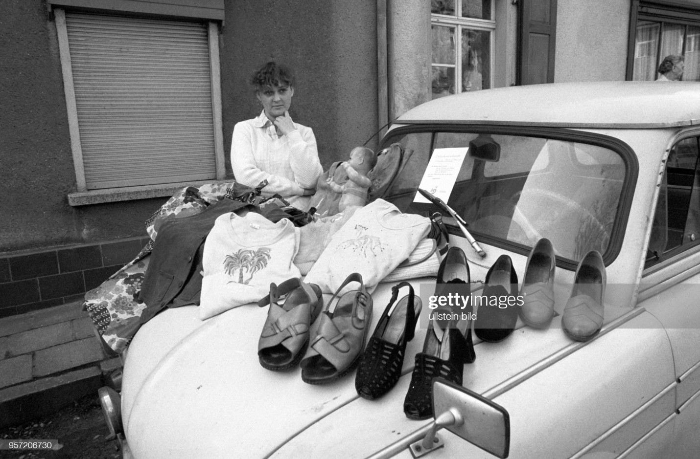 A woman offers shoes and clothing at a flea market in Gerbstedt in the copper mining region of Mansfelder Land in May 1984. The bonnet of her car serves as the sales area. 