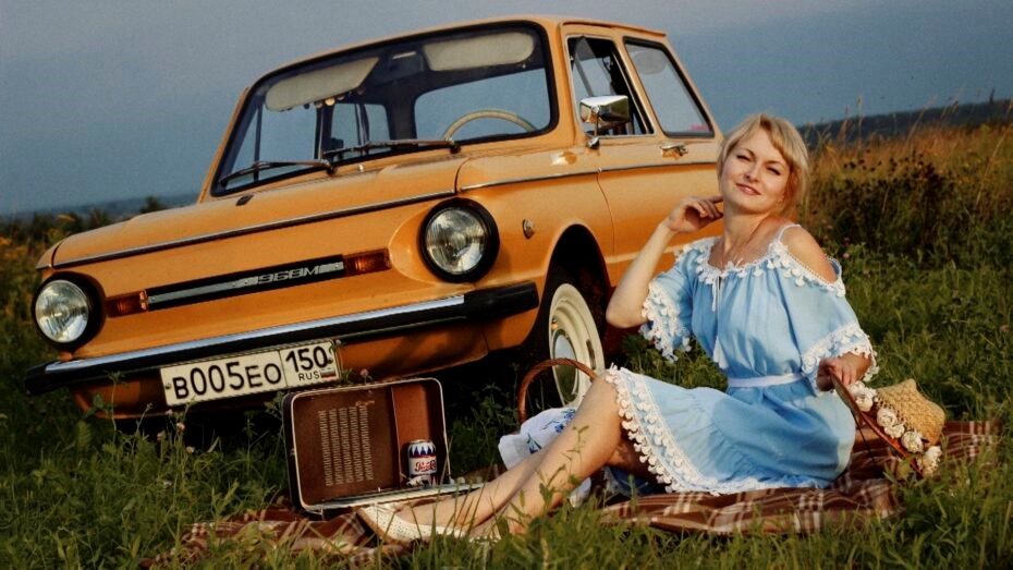 A girl beside a Russian car.