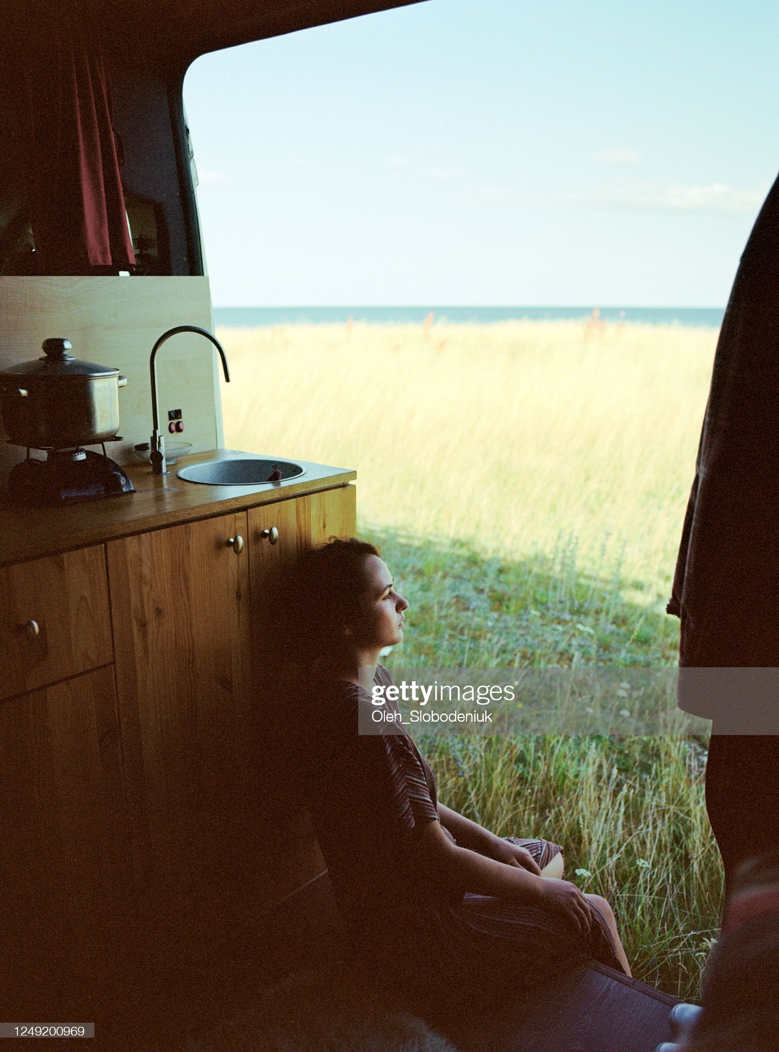 Young Estonian woman looking at scenics from camper van.