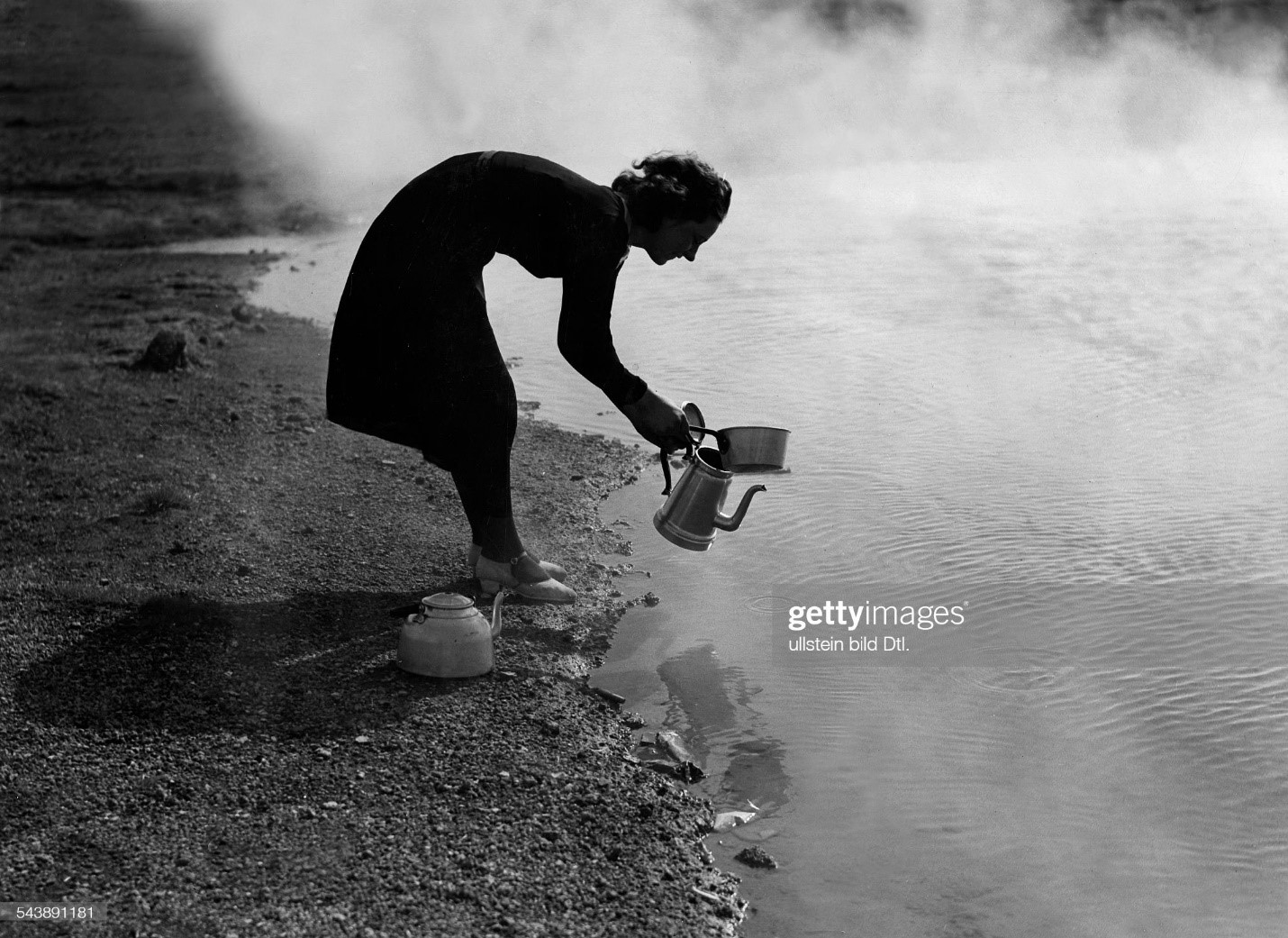 Icelandic woman getting hot water for a tea or coffee near by a geyser in 1935. 