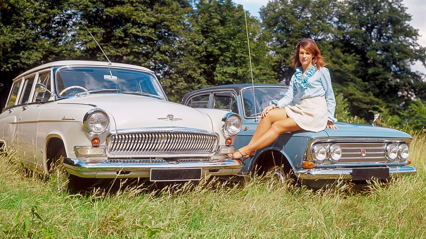 A woman and 2 Soviet cars.