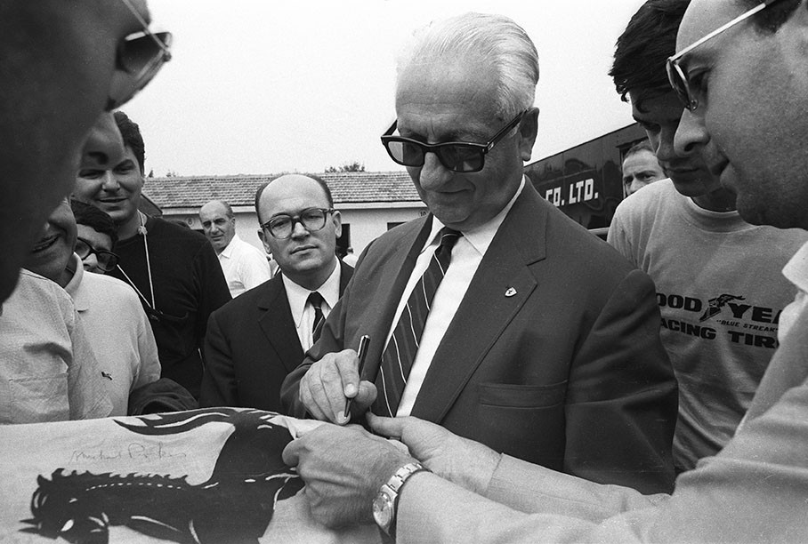 Enzo Ferrari gives autographs to waiting fans at Monza in 1966.