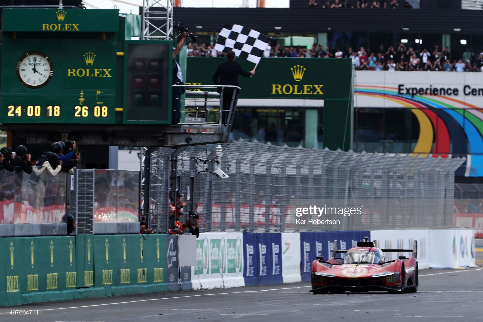 The race winning Ferrari 499P of Alessandro Pier Guidi (driving), James Calado and Antonio Giovinazzi takes the checkered flag at the finish of the 100th anniversary 24 Hours of Le Mans race at the Circuit de la Sarthe on June 11, 2023 in Le Mans, France. 