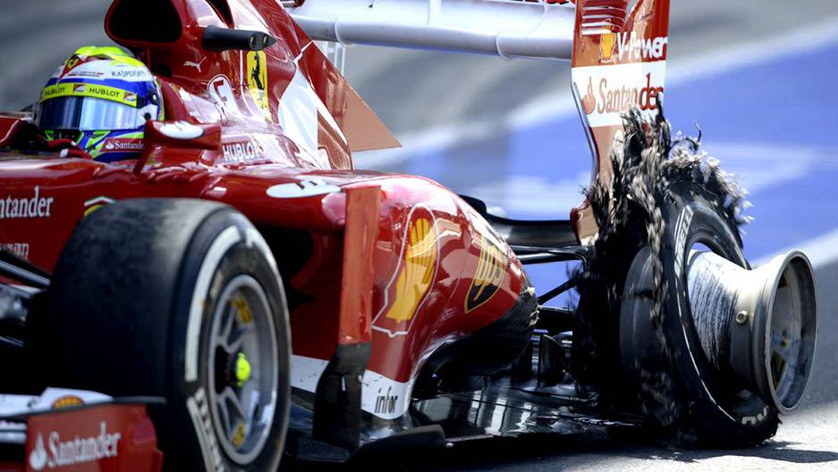 A Ferrari F1 with a destroyed tyre,