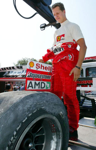 Michael Schumacher checks a tyre of his Ferrari F1.