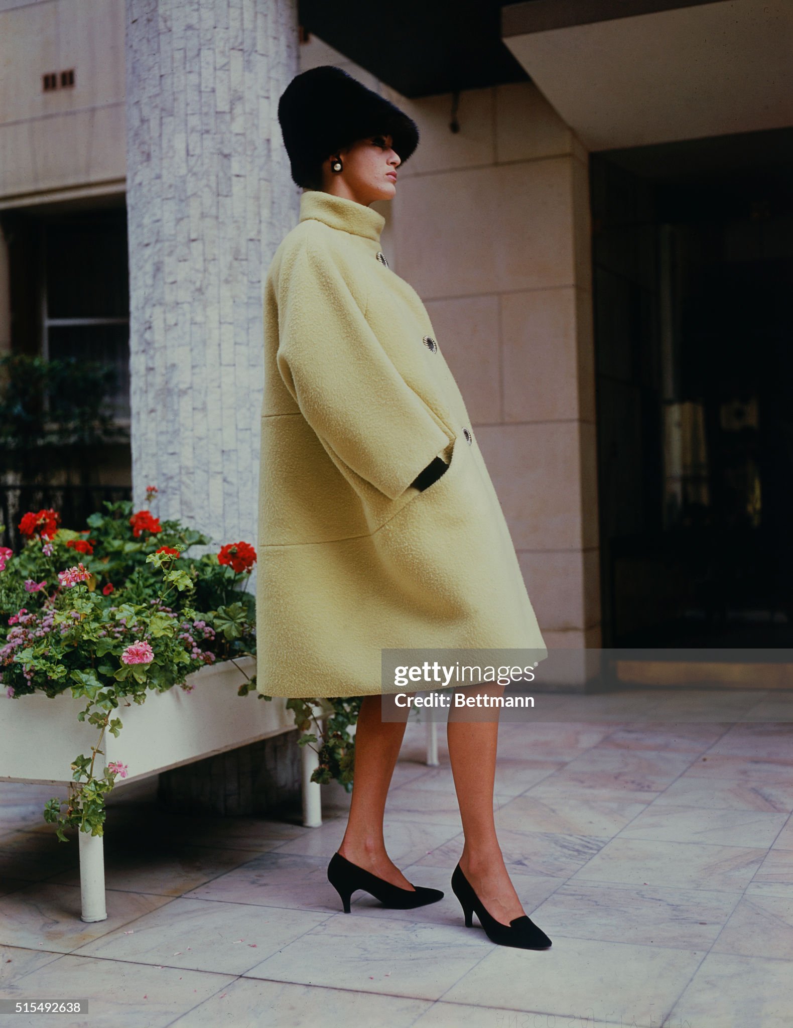 A model wears a pastel yellow coat on August 13, 1963. 