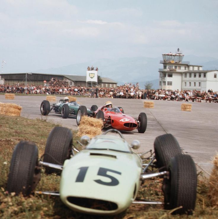 Bandini on the way to victory on the Zeltweg Airfield circuit, Austrian GP, Ferrari 156 Aero in August 1964. He is passing Trevor Taylor’s abandoned BRP Mk1 BRM, broken suspension.