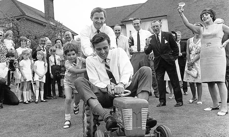 Jim Clark holding on to Damon Hill’s tractor while being pushed by Graham Hill on 02 June 1966.