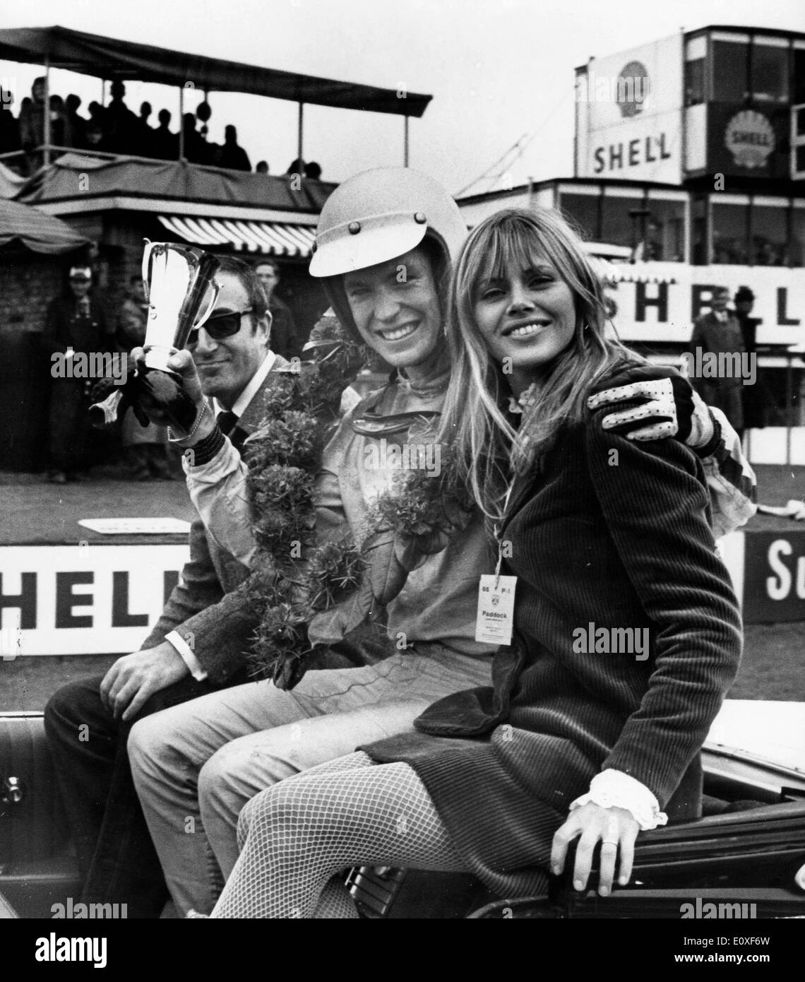 August 06, 1966, London, England. Actress Britt Ekland seated with Chris Irwin - the winner of the Formula III Trophy race - and her husband, actor Peter Sellers, after the race. 