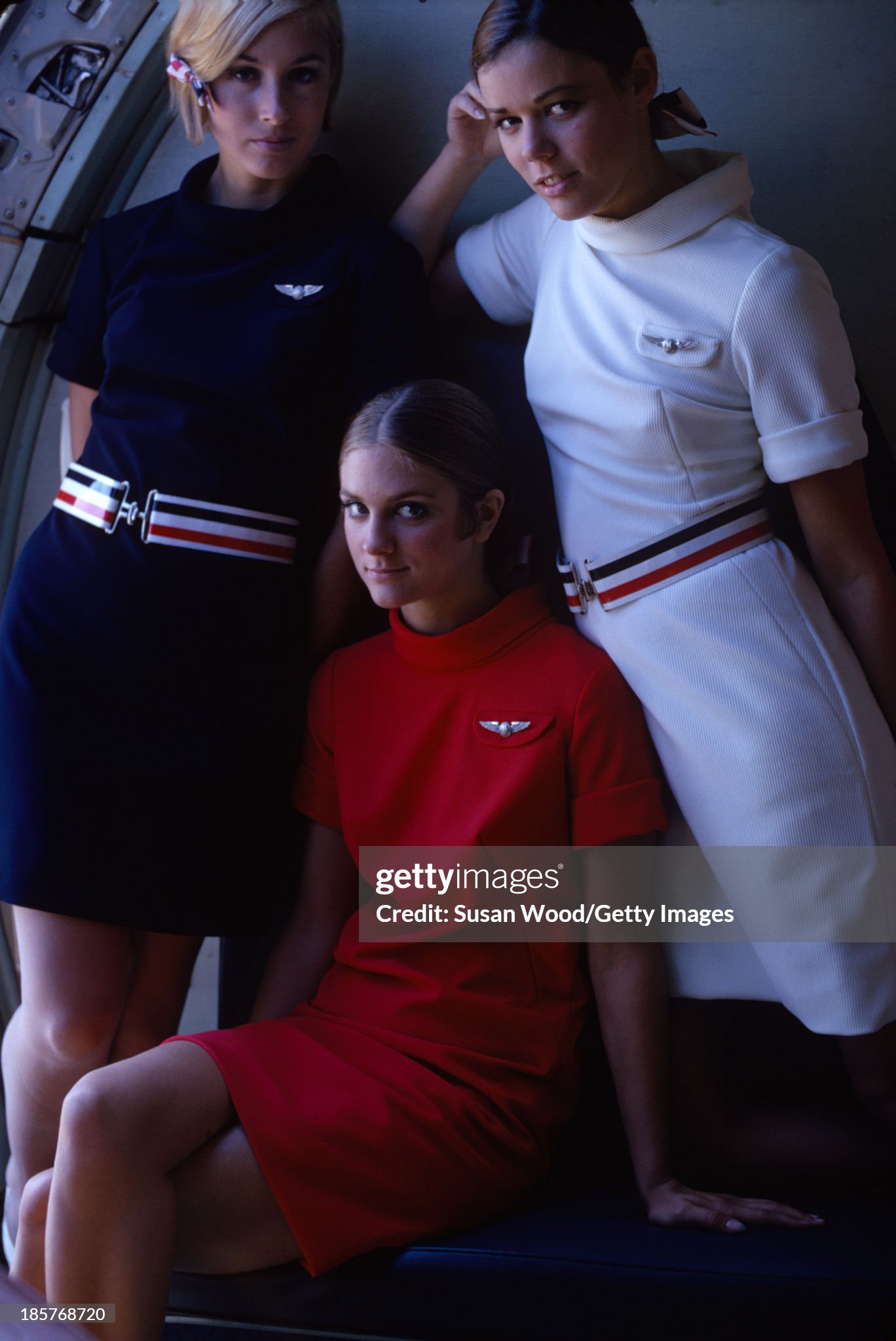 Portrait of a trio of American Airlines air stewardesses as they pose, in uniform, on an airplane, September 1967. The photo was taken as part of a billboard ad campaign for the airline. 
