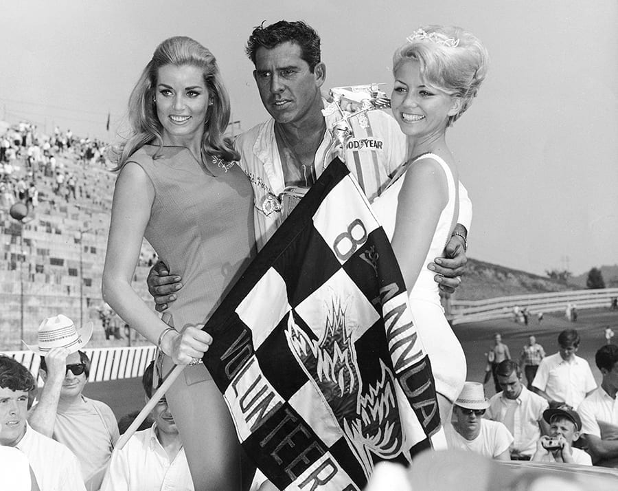Stock car driver David Pearson celebrating with the almost now defunct glamour girls of motor racing in 1968.