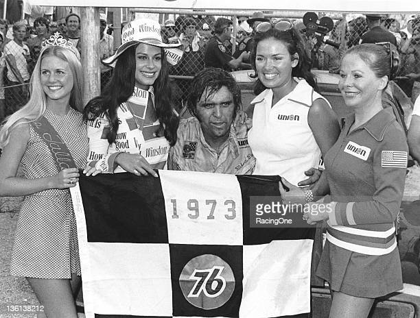 A tired Dick Brooks is joined by a bevy of race queens following the only NASCAR Cup victory of his career, the Talladega 500, at Alabama International Motor Speedway on August 12, 1973.