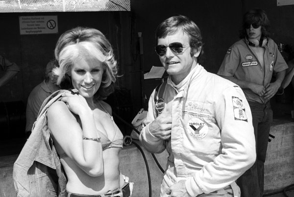 Peter Revson, McLaren, talks with a female visitor in the pits at the Austrian GP on 19 August 1973. 