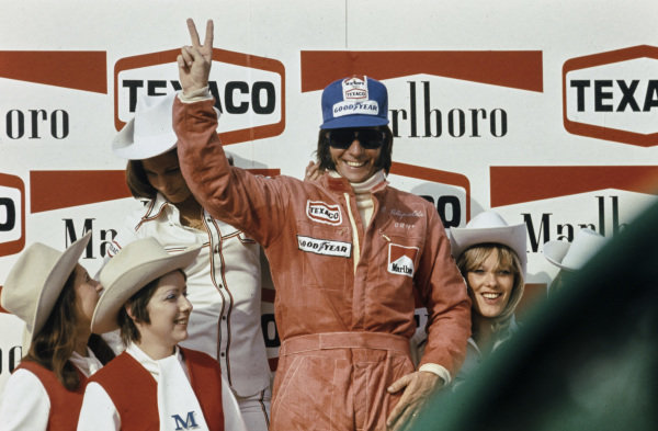 Emerson Fittipaldi celebrates victory on the podium with the Marlboro sponsorship girls at the Belgian GP in Nivelles on 12 May 1974. 