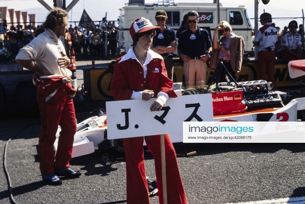 A Marlboro grid girl holding Jochen Mass grid sign as the driver and his McLaren M26 Ford wait behind her during the Japanese GP at Fuji International Speedway on 23 October 1977.