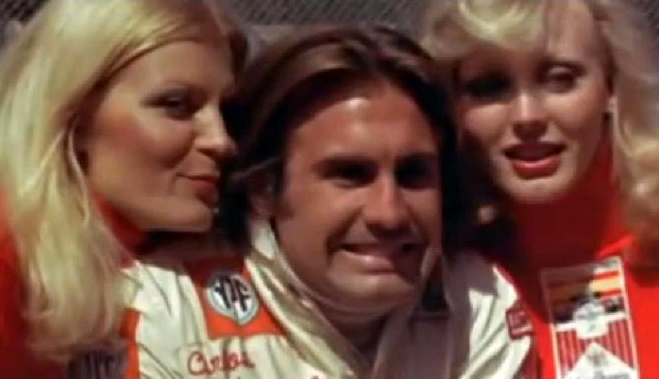 Carlos Reutemann and two grid girls.