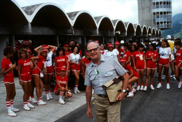 Professor Sid Watkins, FISA doctor, is swarmed by the Coca Cola girls at the Brazilian Grand Prix in Jacarepaguá, Rio de Janeiro, on 21 March 1982. 