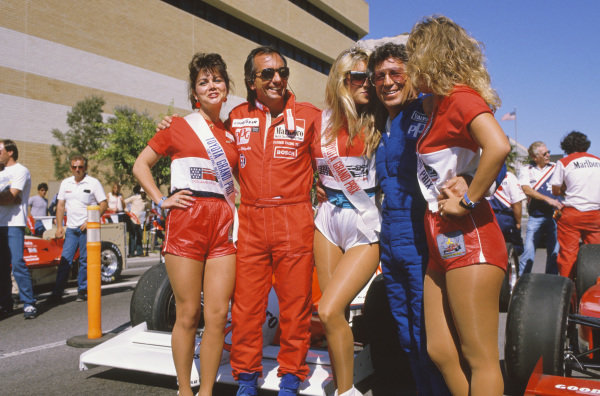 Emerson Fittipaldi and Mario Andretti with three girls at the Grand Prix of Long Beach on 13 April 1986.
