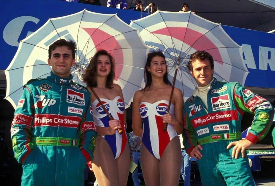 Alessandro Zanardi and Andrea De Cesaris, Jordan 191, with two girls at the Japanese Grand Prix in Suzuka on 20 October 1991.