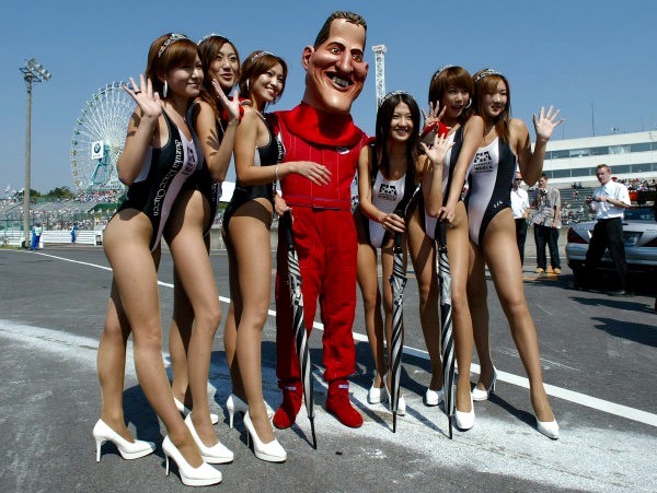 Michael Schumacher caricature and Japanese grid girls at Suzuka on 13 October 2002. 