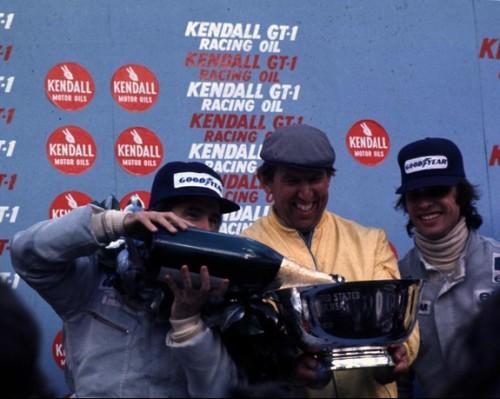 Francois Cevert on the podium with Jackie Stewart and Ken Tyrrell.
