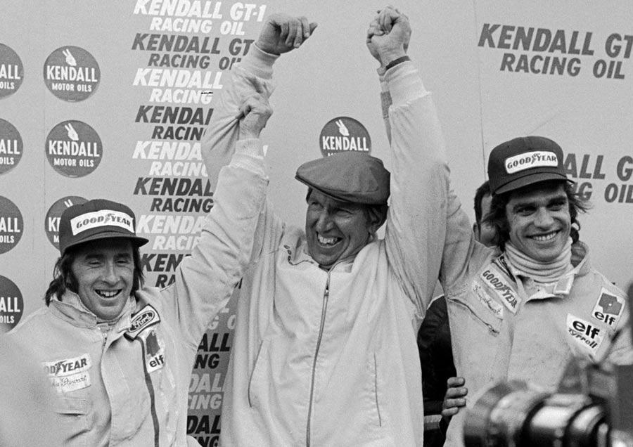 Francois Cevert on the podium with Jackie Stewart and Ken Tyrrell.