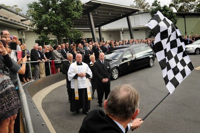A checkered flag is waved to farewell Australian motorsport legend Jack Brabham at his funeral on the Gold Coast. 