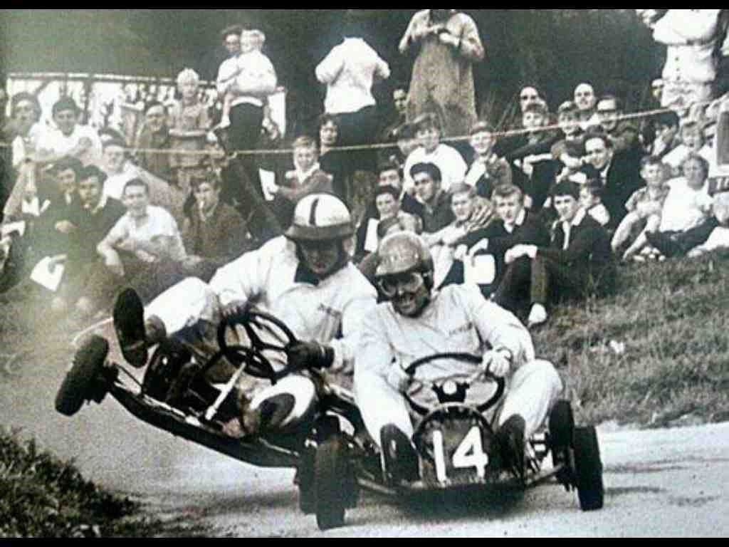 Here we see Jack Brabham demonstrating his exuberant racing methods that earned him the nickname “Black Jack” to a young Bruce McLaren.