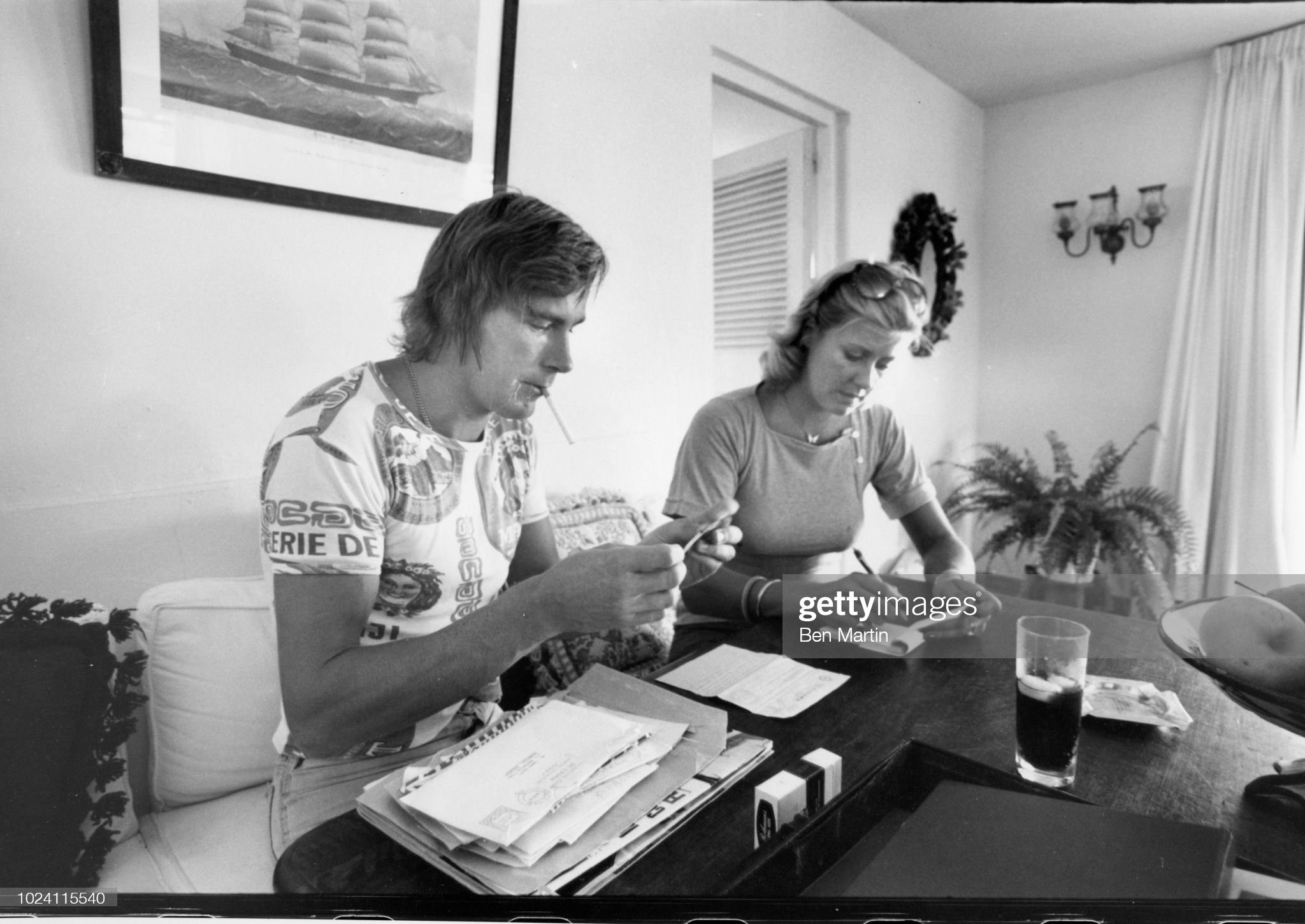 James Hunt signing autographs at home with his assistant, UK, 16th September 1977. 