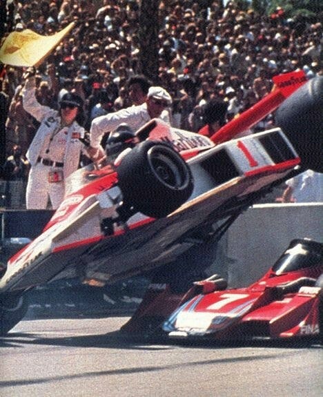 James Hunt, McLaren M23 Ford, locks up and takes off over the front wheel of John Watson’s Brabham BT45B Alfa Romeo in the chain reaction of collisions at Cooks corner on the first lap at the US Grand Prix West in Long Beach on 03 April 1977.
