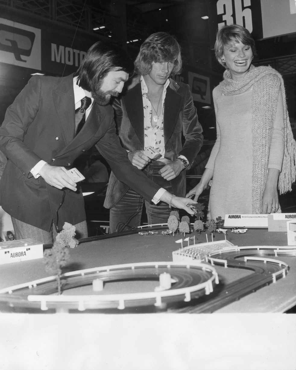 Mike Wilds and James Hunt playing with the Aurora model race track at the 12th International Racing Car Show at Olympia on 02 January 1974. 