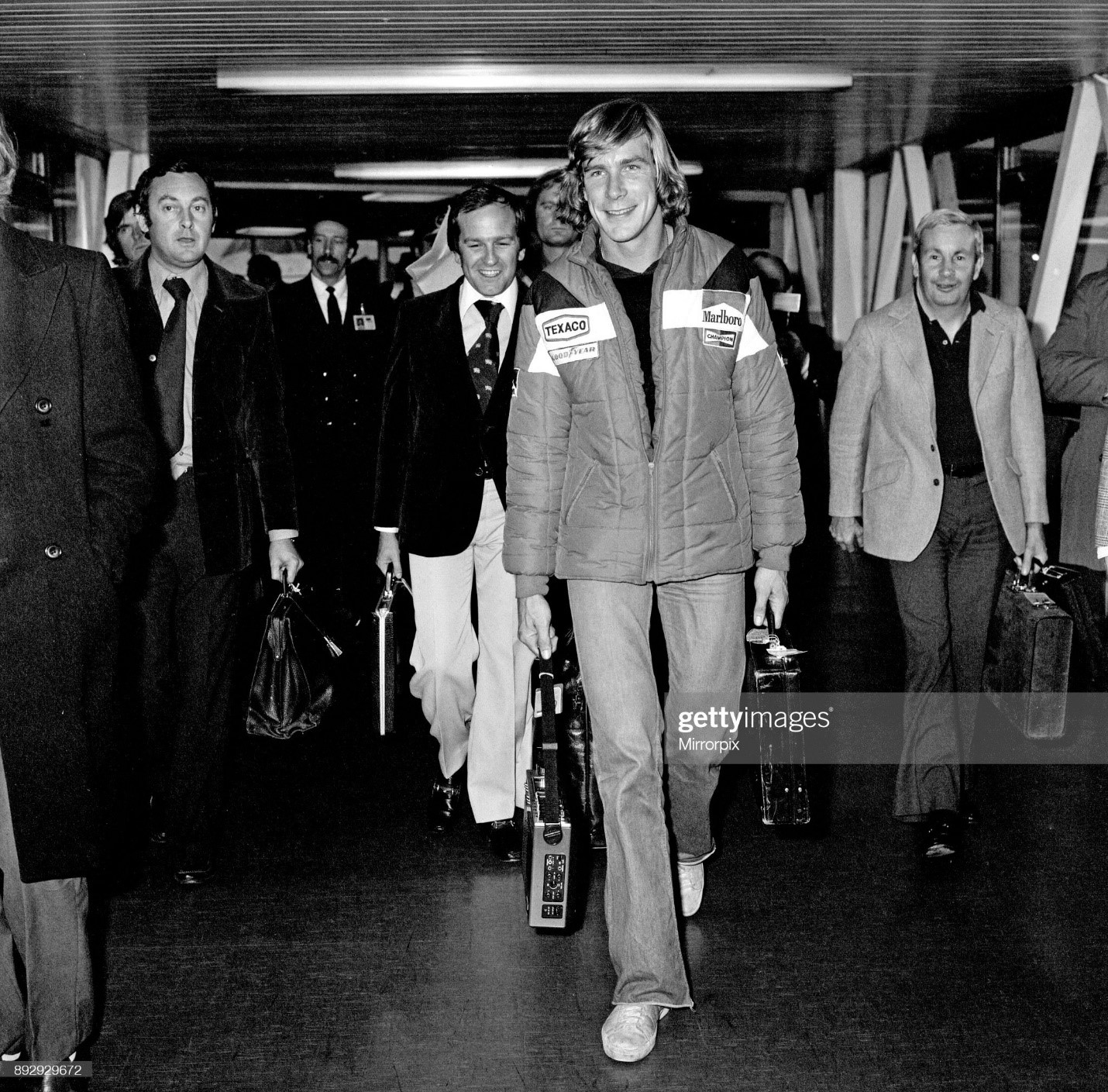 James Hunt, the new World Motor Racing Champion, received a hero's welcome when he flew into Heathrow Airport this morning from Japan. The 29-year-old McLaren Formula One driver was greeted by most of his family and girlfriend Jane Birbeck. Picture, taken 26th October1976, shows James Hunt walking through to the arrival lounge and press conference.