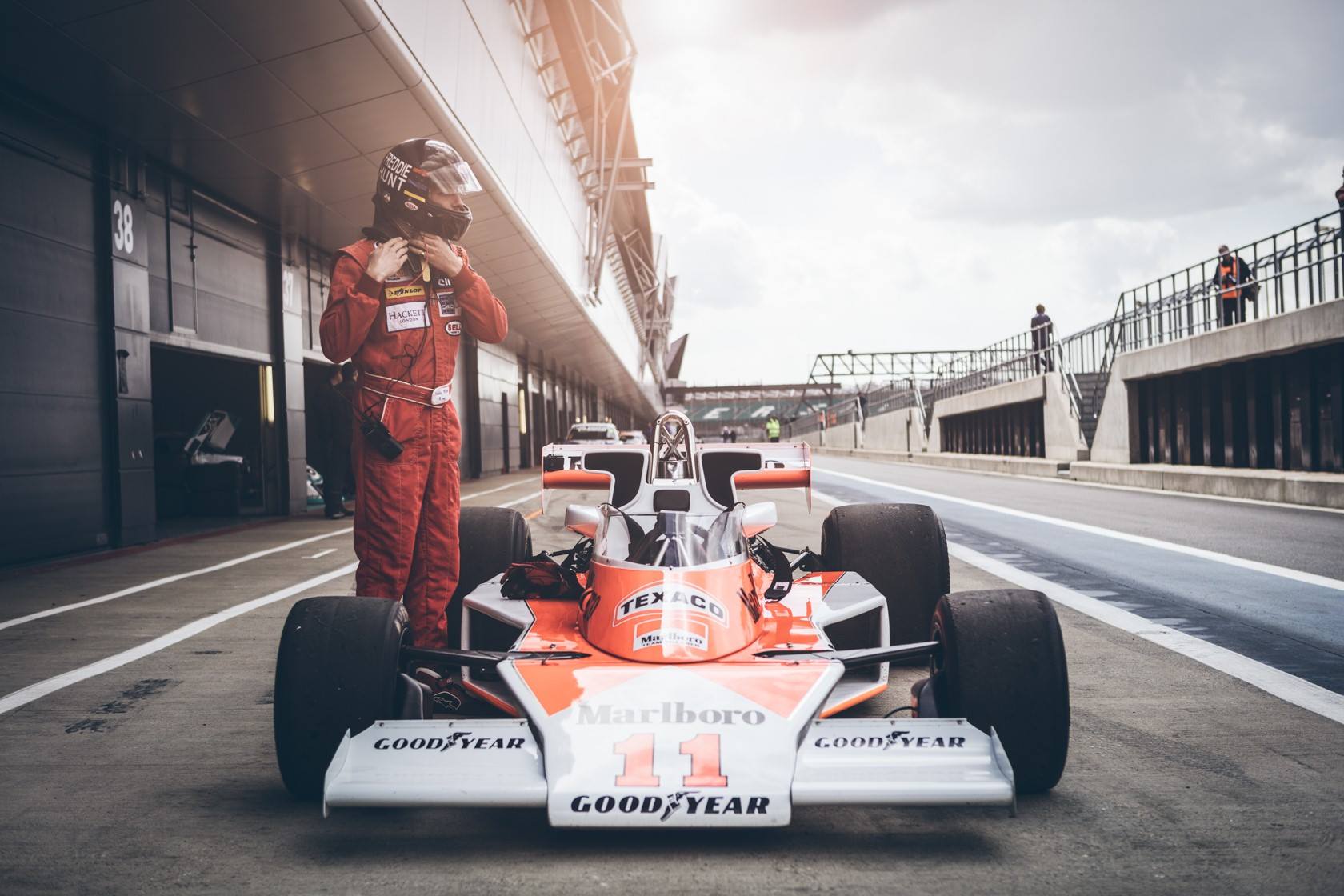 The McLaren M23 driven by Freddie Hunt at Silverstone in April 2016 and with McLaren Team Manager Alastair Caldwell overlooking.