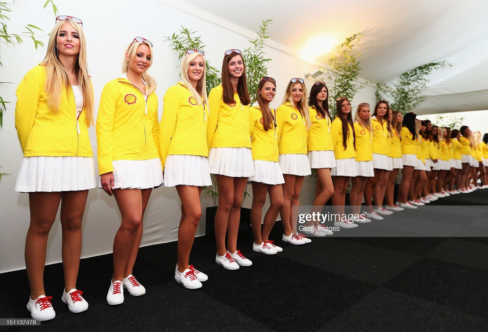 Shell promotion girls form a guard of honour at their hospitality unit before the Belgian Grand Prix at the Circuit of Spa Francorchamps on September 2, 2012. 